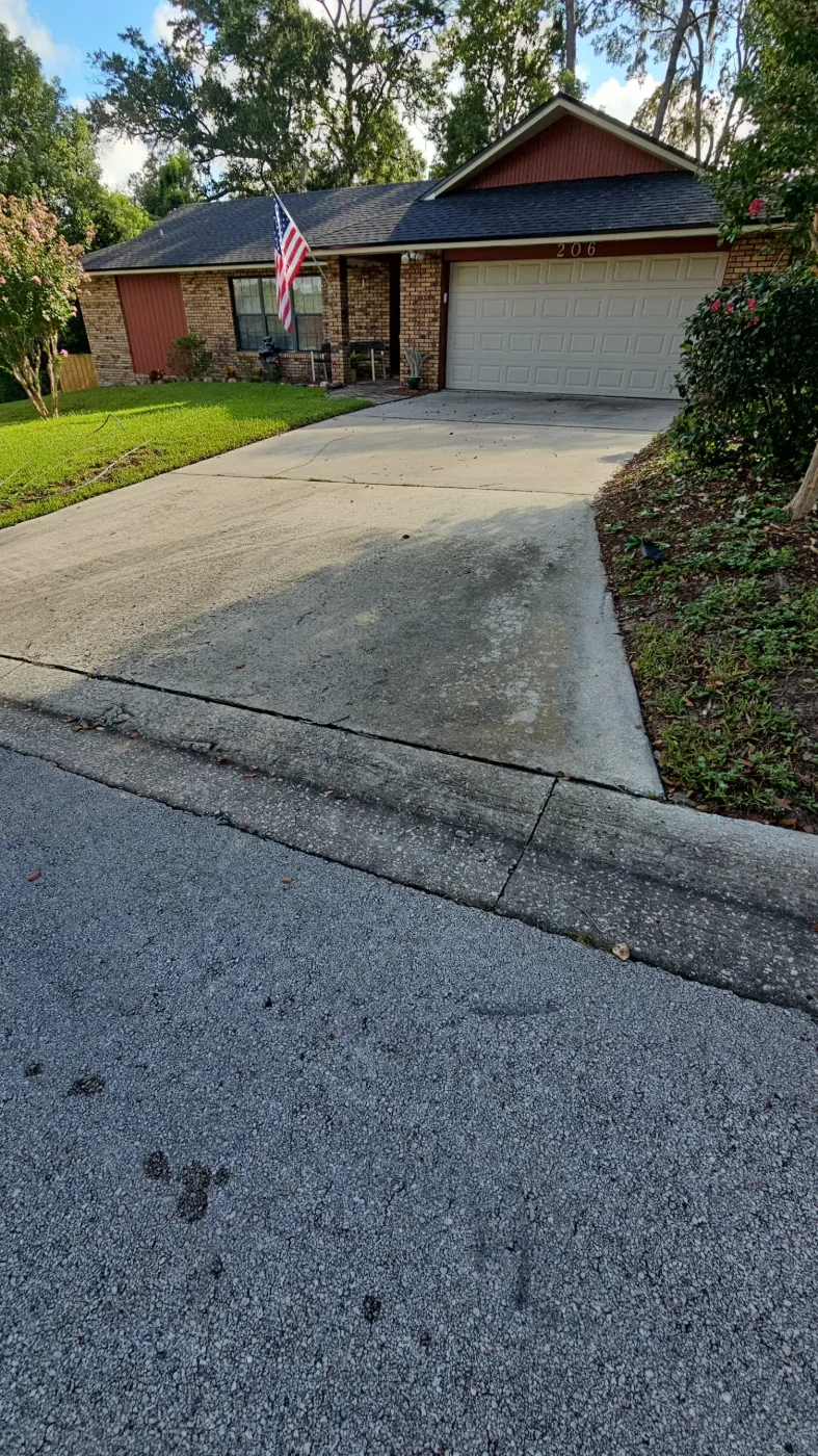 Concrete driveway streaked with mildew and dirt before pressure washing